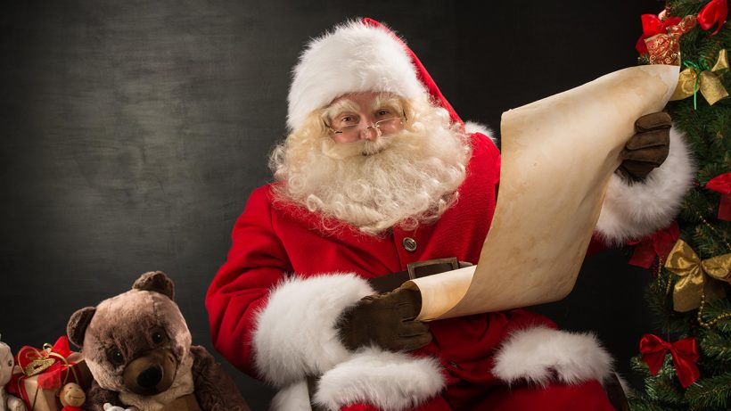 Hình ảnh ông già Noel cười tươi cầm danh sách phát quà
