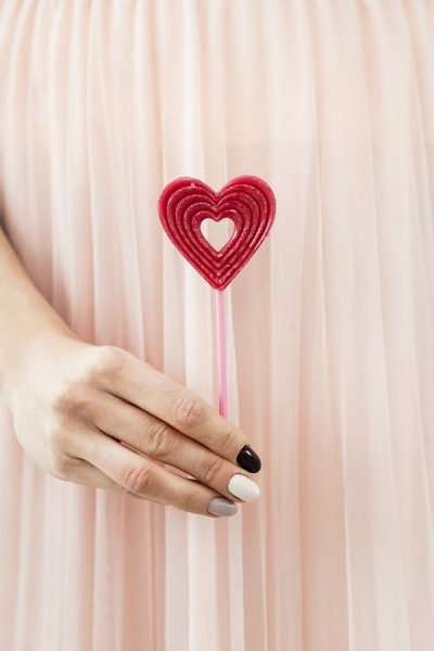 Hình ảnh Valentine đẹp bàn tay cầm cây kẹo trái tim